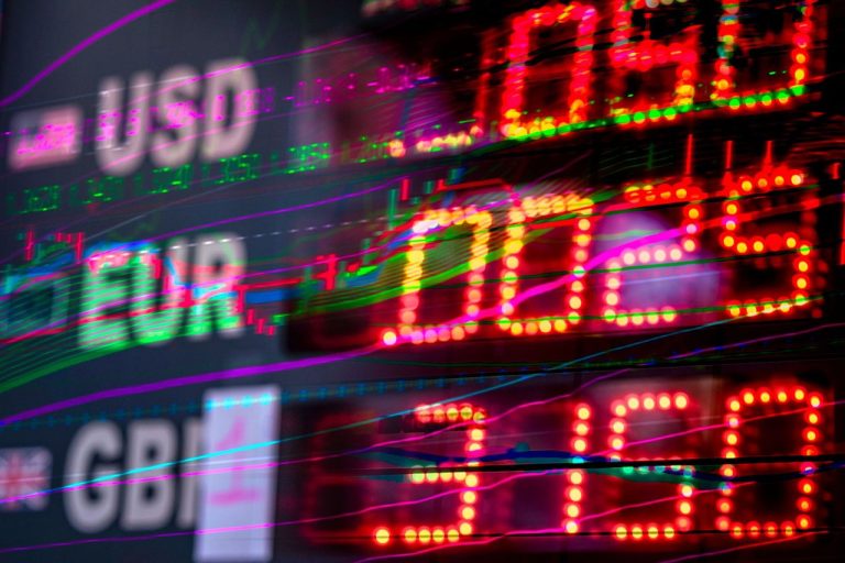 Pressão global leva dólar novamente acima de R$ 5 no Brasil Tela com cotações de dólar, euro e libra esterlina em um painel de mercado financeiro.