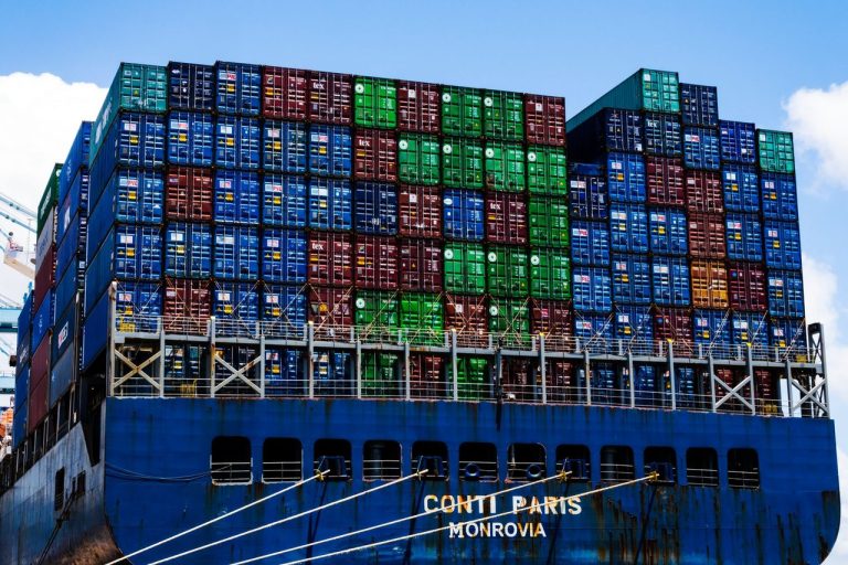 Mercosul e EFTA iniciam nova fase comercial com acordo de livre comércio Contêineres empilhados em um navio cargueiro atracado em um porto.